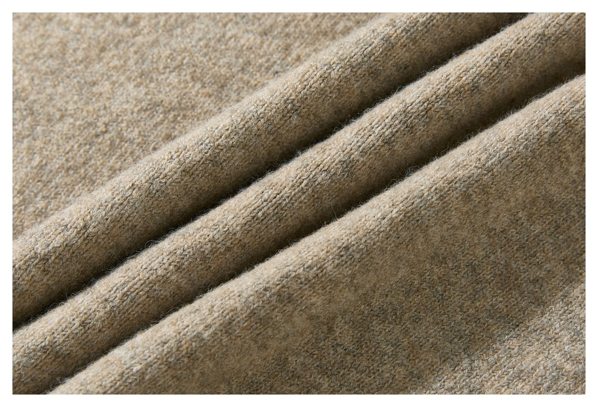 Close-up of tan-brown knitted fabric arranged in soft diagonal folds.