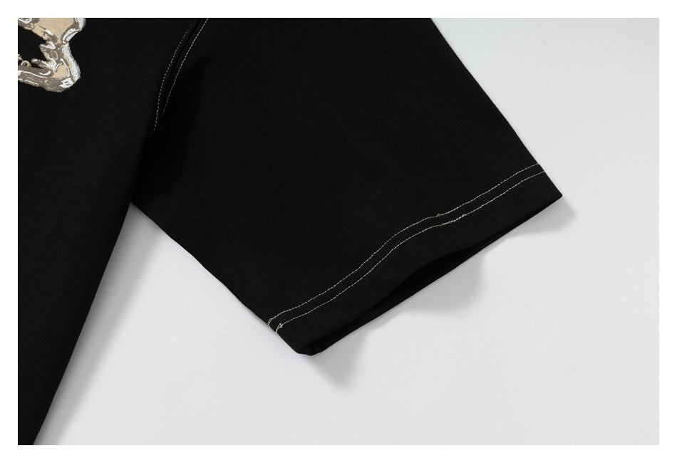 Close-up of a black T-shirt sleeve hem with two rows of contrasting stitching.