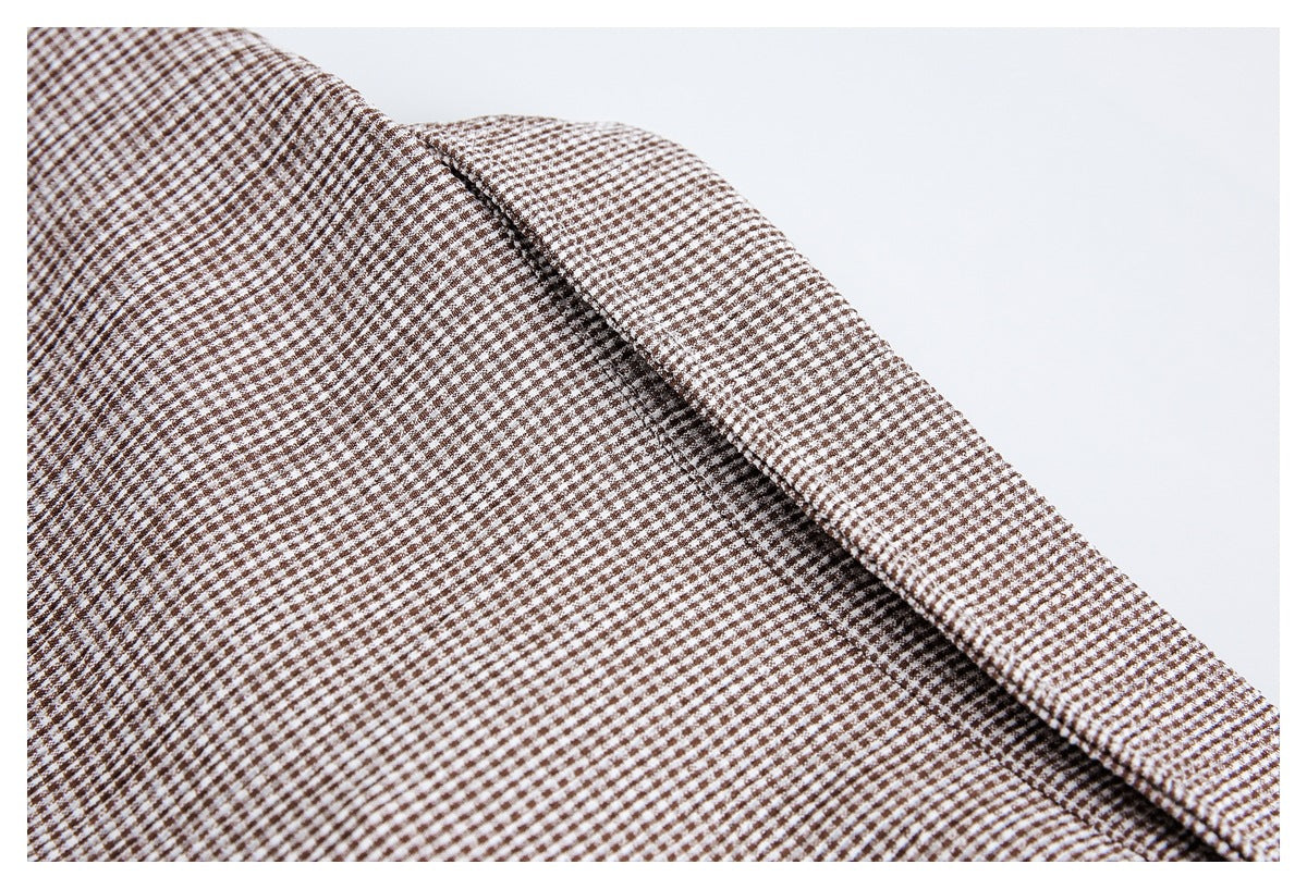 Close-up of a folded edge on brown-and-white small-check fabric.