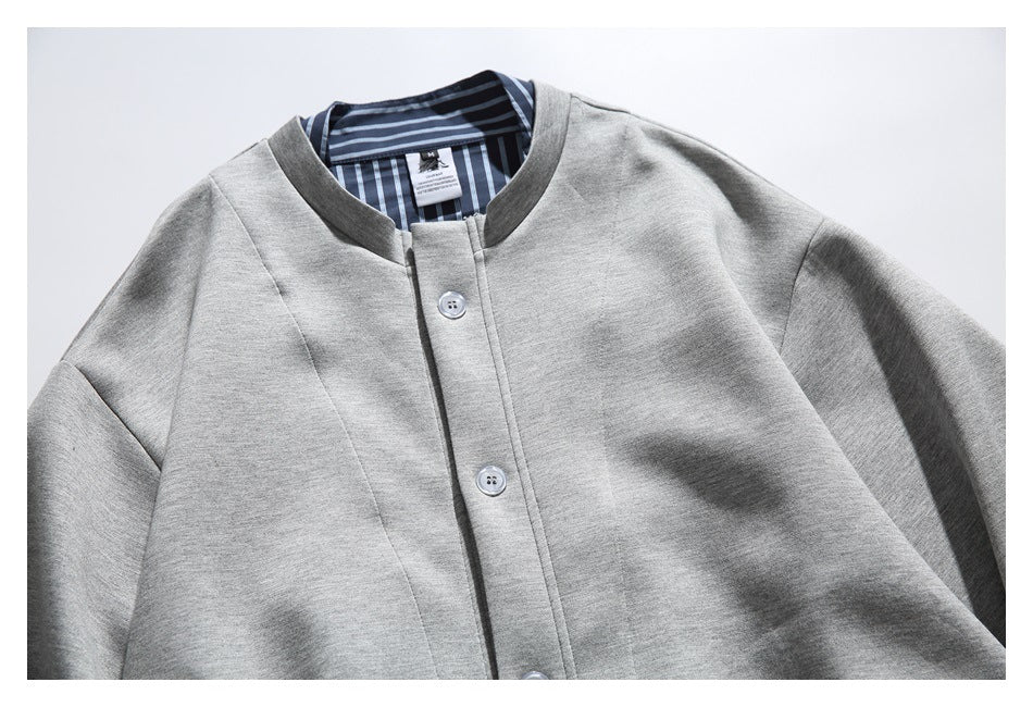 Close-up of the gray jacket's button placket, band collar, and blue striped inner lining.