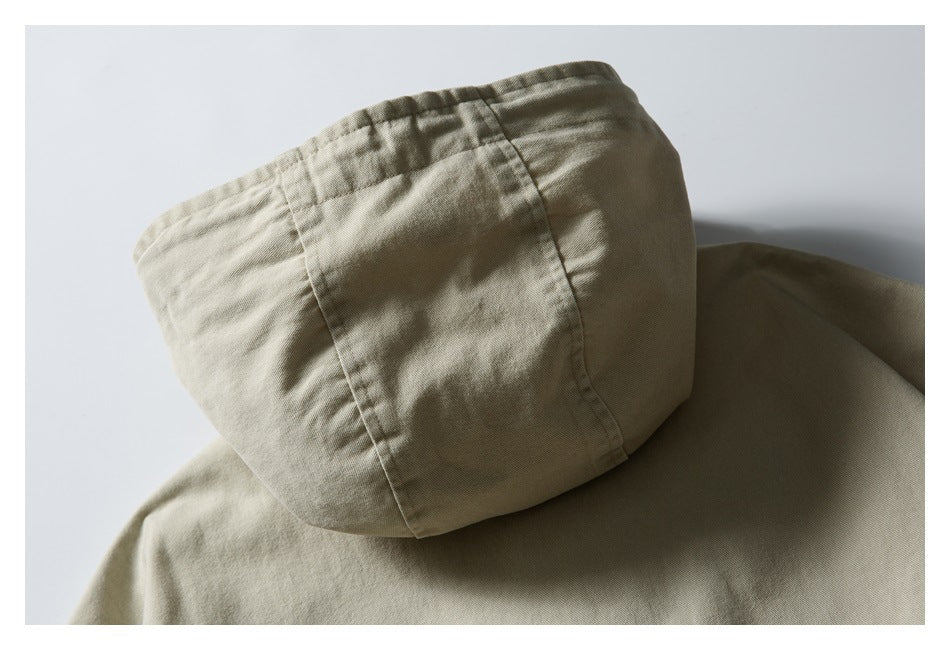 Close view of the back of a beige hooded garment, with the hood and upper back visible.