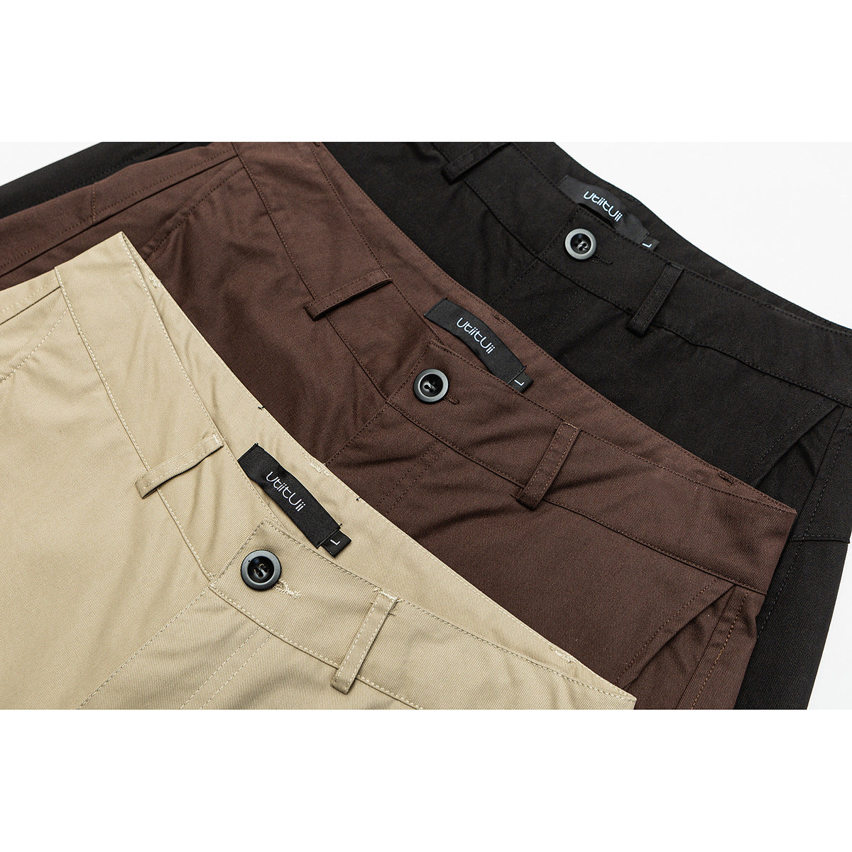 Close-up of three pairs of wide-leg trousers in beige, brown, and black, showing waistbands, buttons, and belt loops.