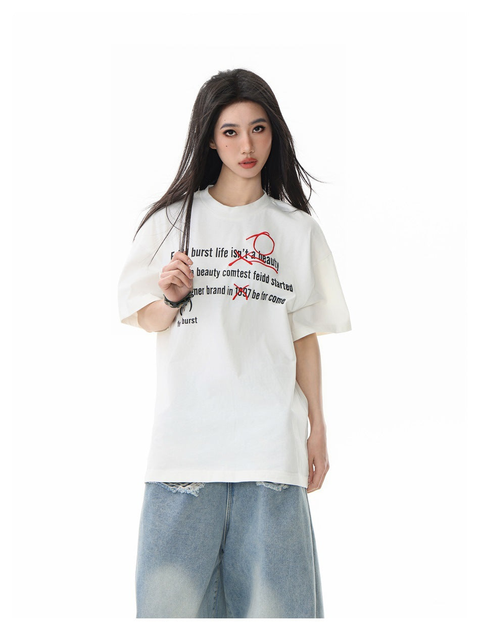 Front view of a model wearing an off-white oversized T-shirt with black text and red graphics; the image crops the jeans