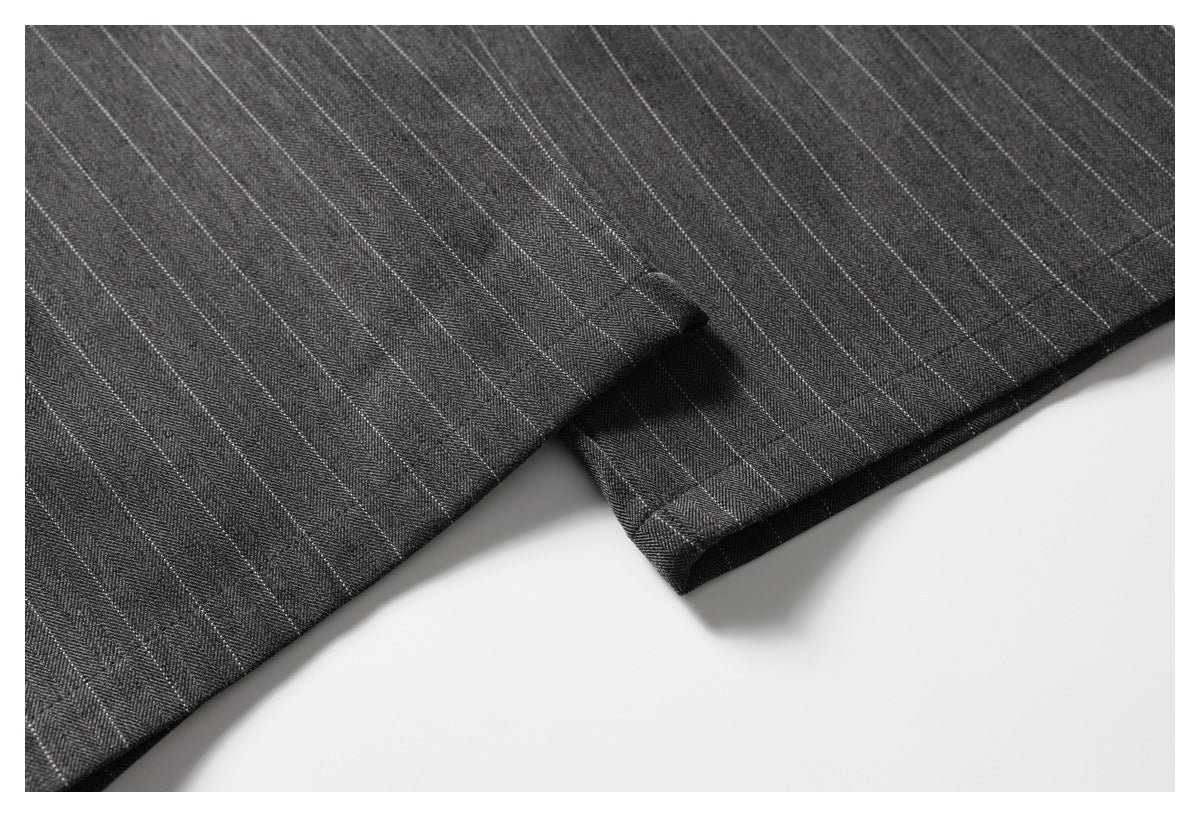 Close-up of the hem and pinstripe fabric on charcoal trousers.