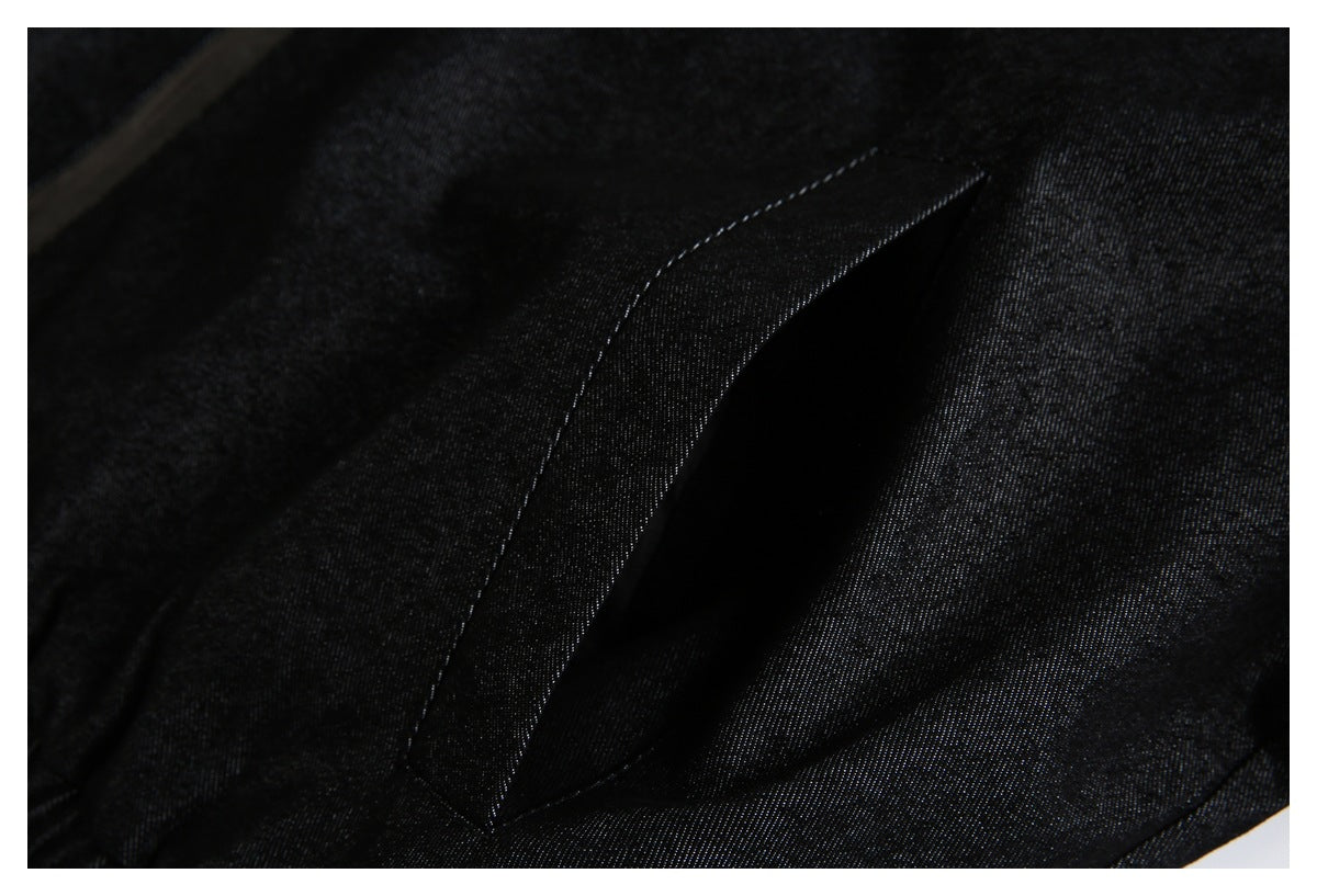 Close-up of black fabric with a narrow stitched pocket opening.