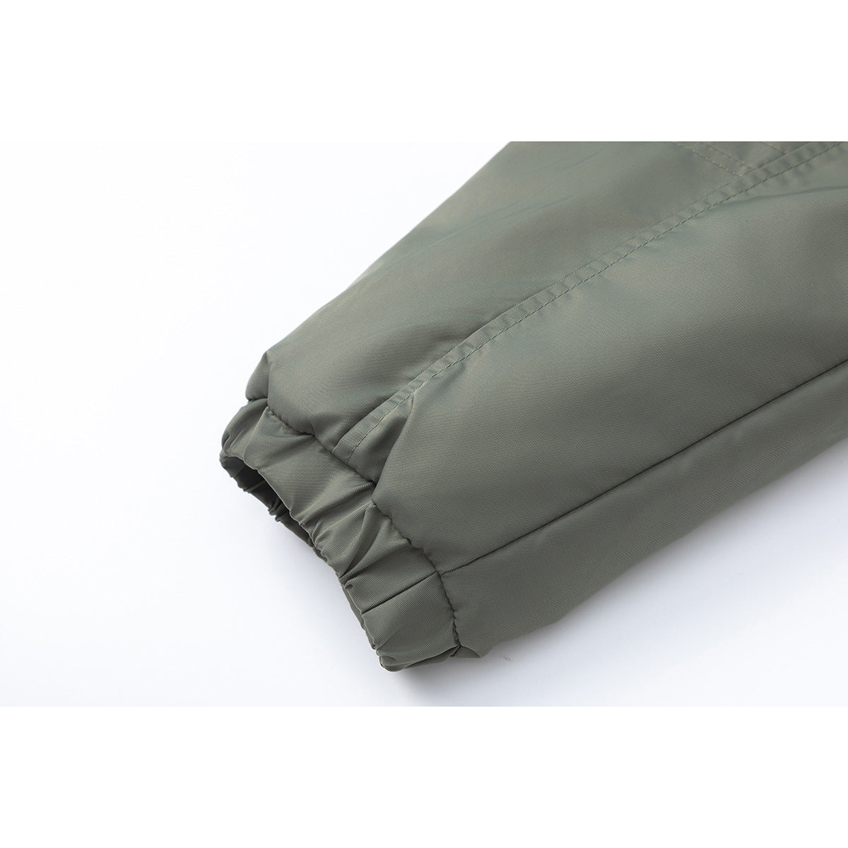 Close-up of an olive-green jacket sleeve ending in a gathered elastic cuff.
