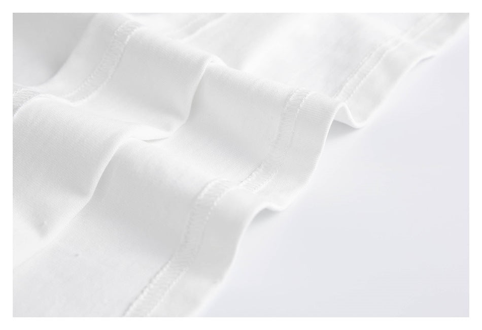 Close-up of white fabric folds and stitched seams against a light background.