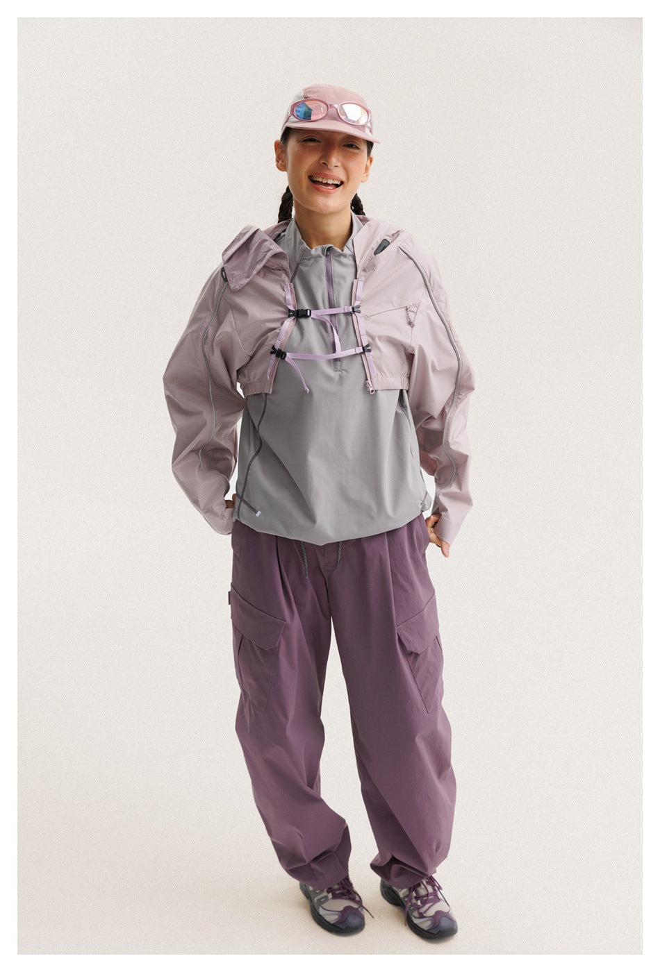 Front view of a person in a cropped mauve jacket over a gray pullover and plum cargo pants.