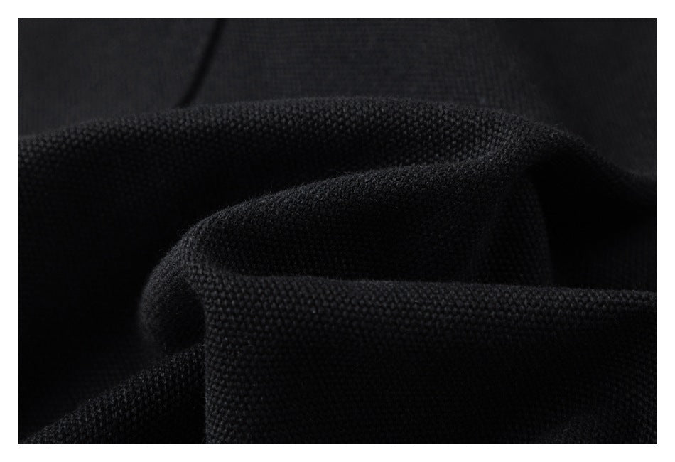 Macro view of textured black fabric gathered into soft folds.