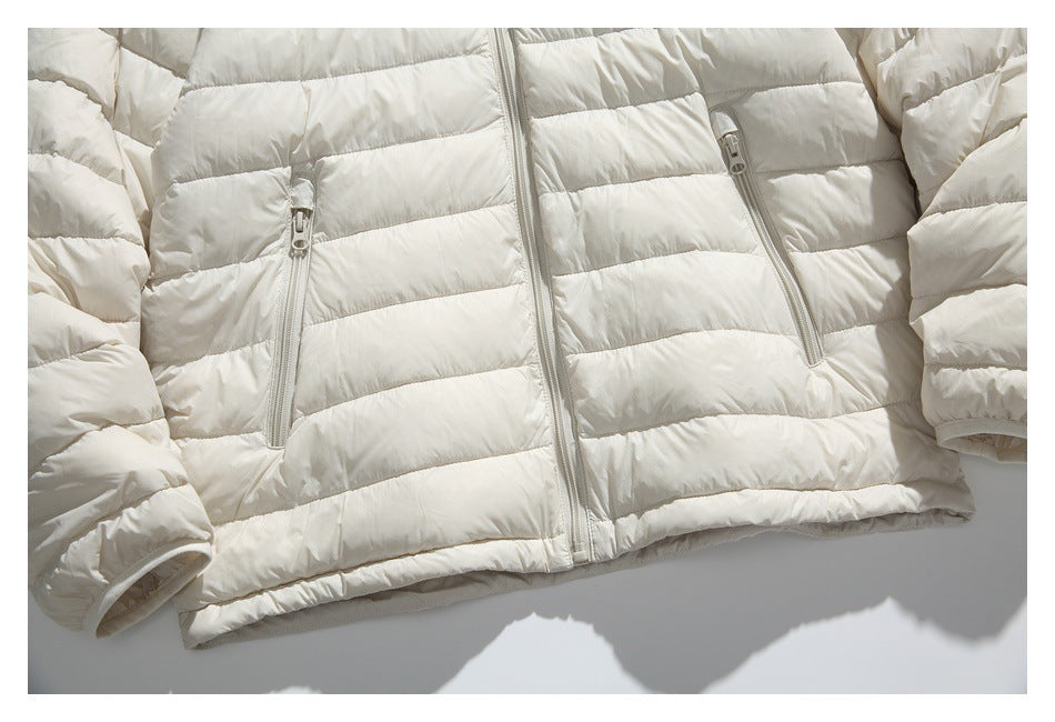 Ivory quilted jacket laid flat, showing its front zipper, two zip pockets, and long sleeves.