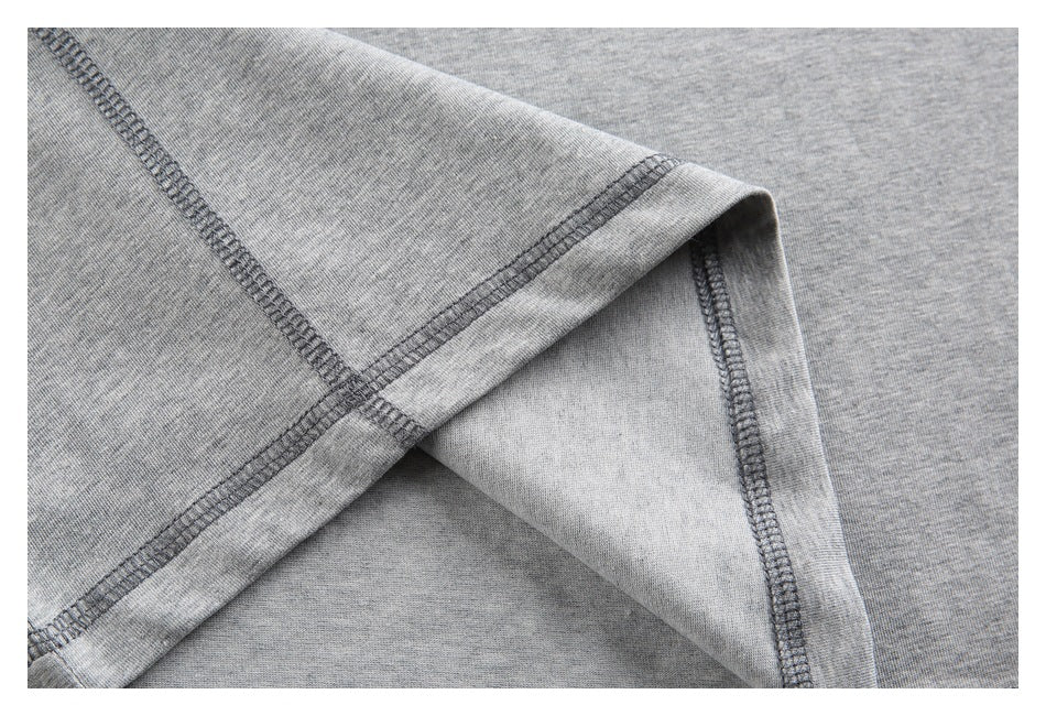 Close-up of a folded section of heather-gray shirt fabric showing dark overlock stitching.
