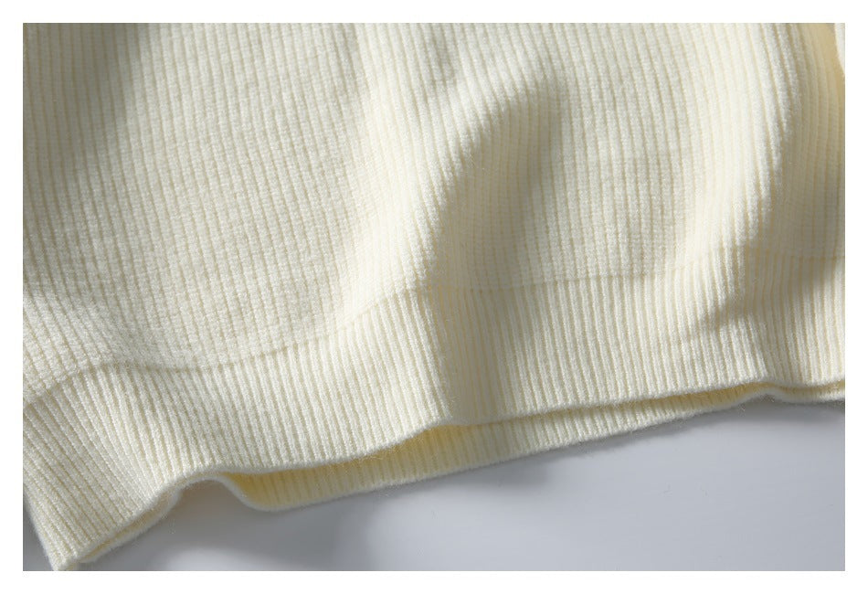 Close-up of the ivory cardigan's ribbed knit fabric and lower hem.