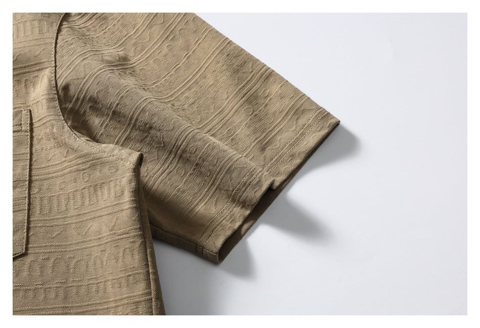 Close-up of a short sleeve and patterned fabric on the tan shirt.