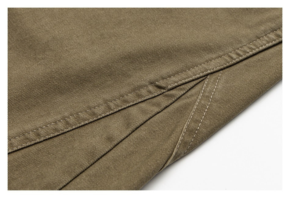 Close-up of brown trouser fabric with a folded hem and parallel stitching.