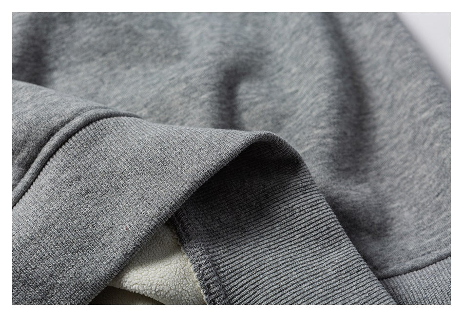 Close-up of a gray sweatshirt cuff with ribbed trim and white fleece lining.