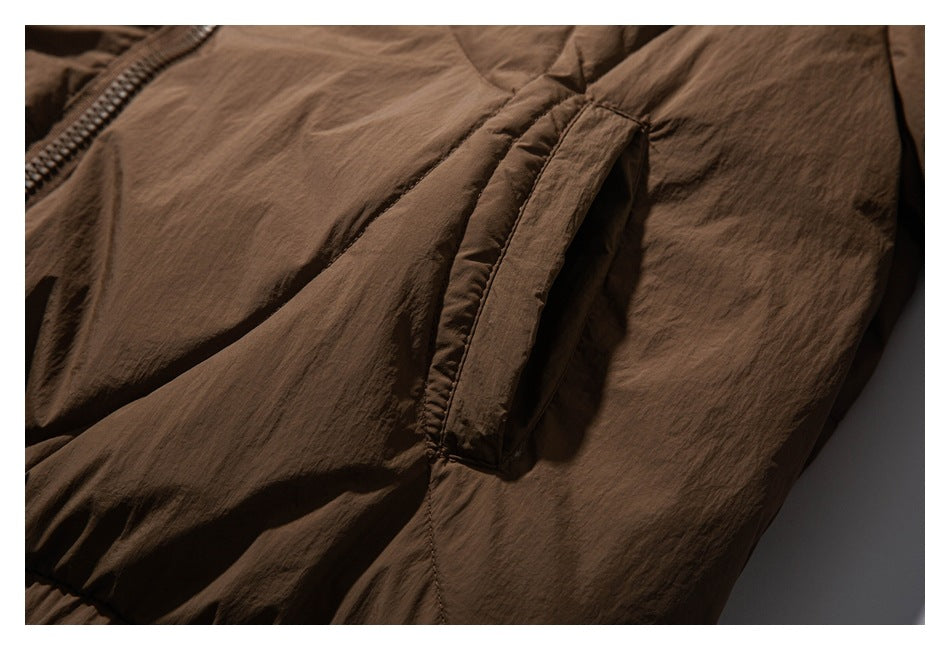 Close-up of a brown jacket's side pocket opening and nearby seams.