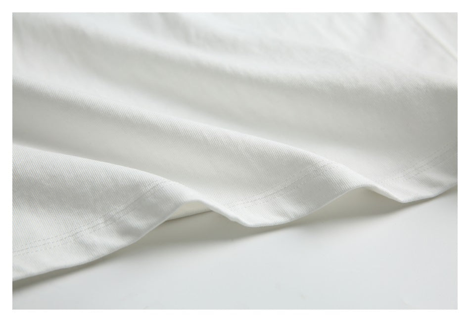 Close-up of the white garment's double-stitched hem and draped fabric.