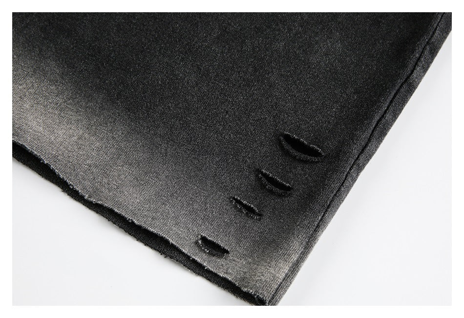 Close-up of a dark shirt hem with several small distressed slits.