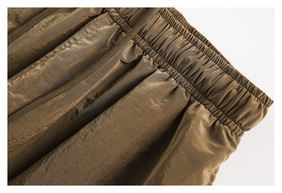 Close-up of the brown shorts' elastic waistband and gathered front fabric.