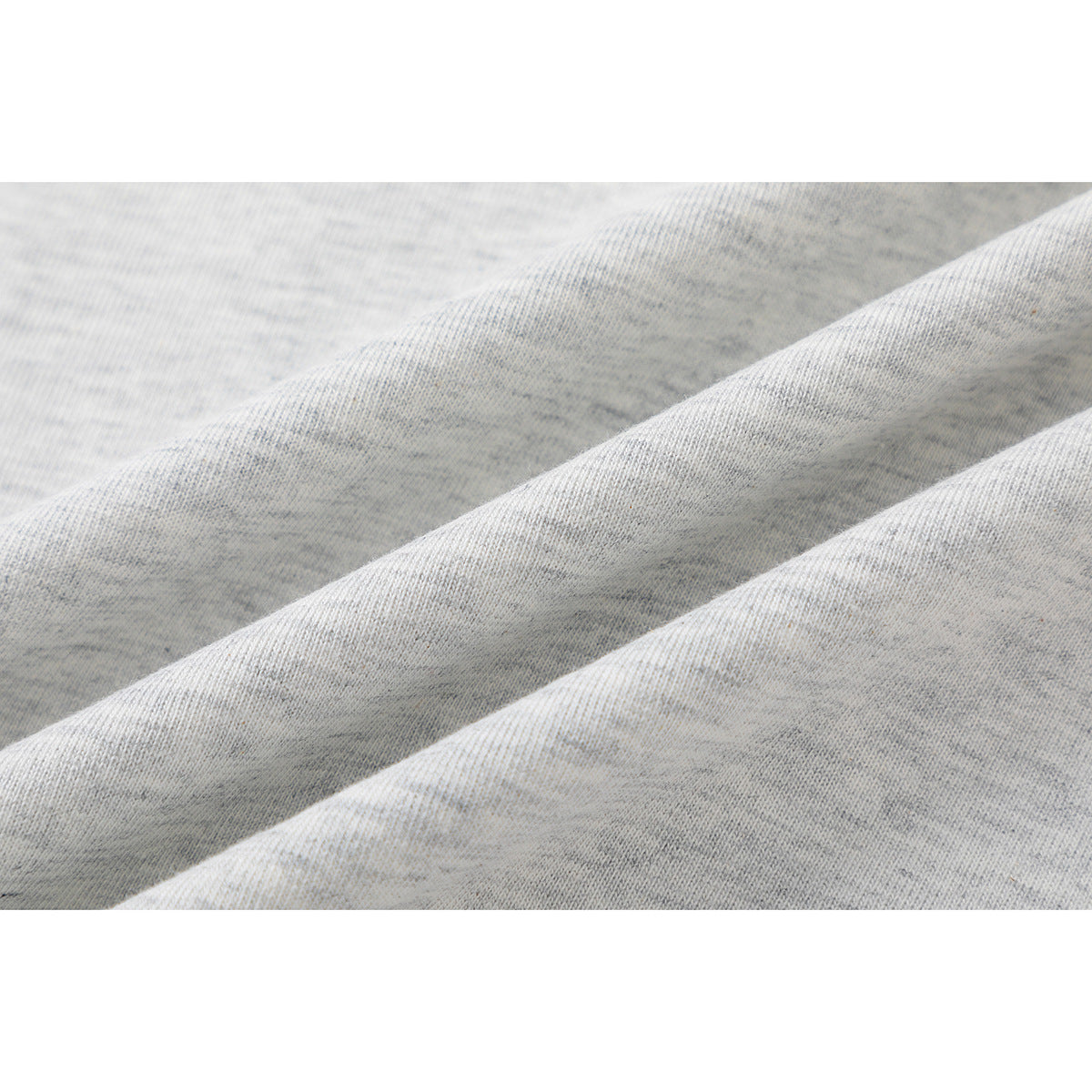 Close-up showing the heather gray T-shirt fabric in soft diagonal folds.