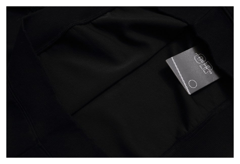 Close-up of the inside of a black garment with a small attached black brand tag.
