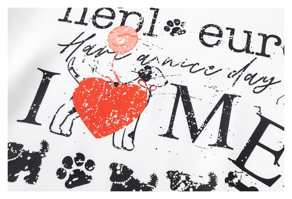 Close-up of a white garment's dog-and-heart graphic, with black lettering, paw prints and a bright red heart.