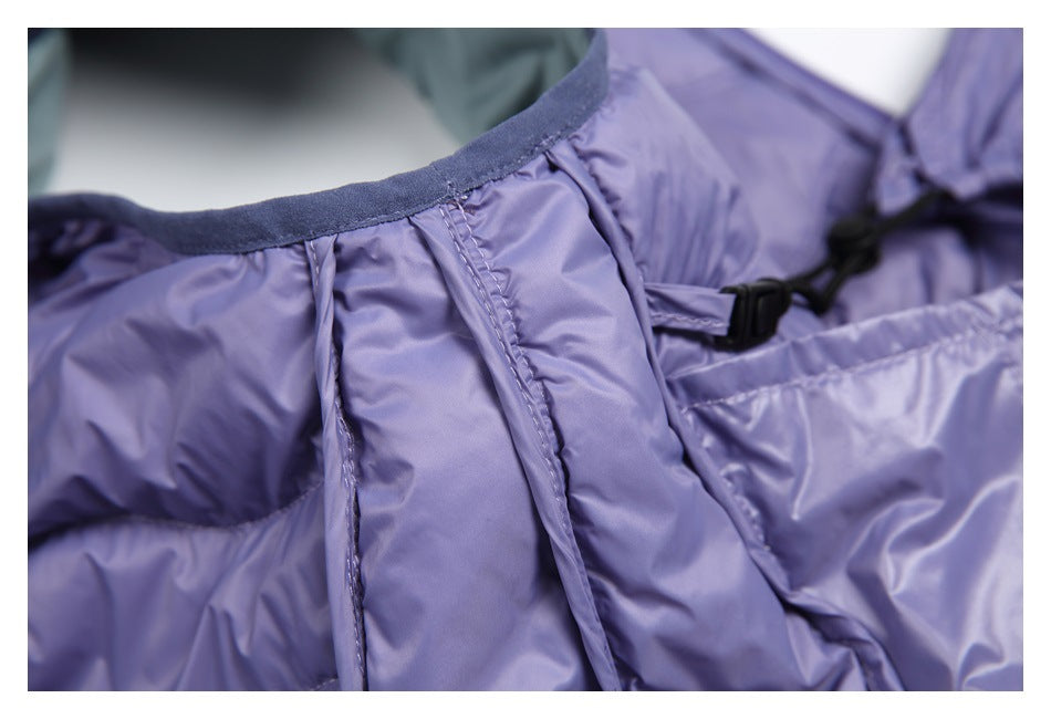 Close-up of lavender garment seams, dark binding, and a black drawcord toggle near the opening.