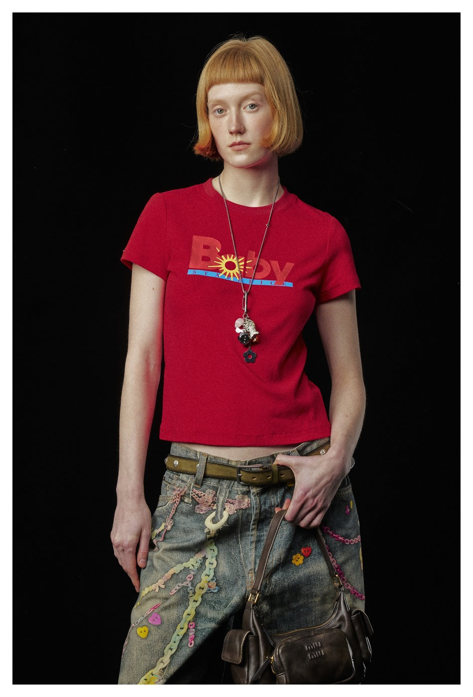 Closer view of a model wearing a red graphic T-shirt with a crew neck and short sleeves.