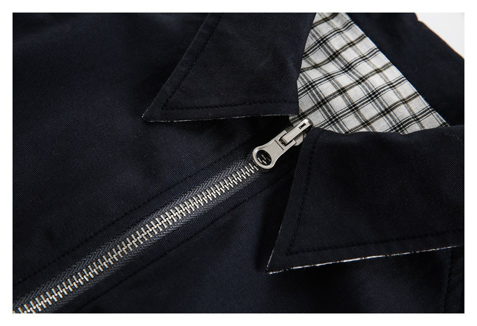 Close-up of the jacket's silver zipper, pointed collar, and black-and-white plaid lining.