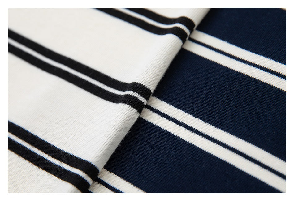 Close-up of white fabric with dark stripes beside navy fabric with white stripes.