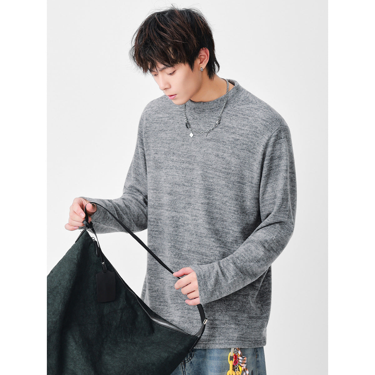 Model wearing a loose gray marled long-sleeve top with a round neckline.