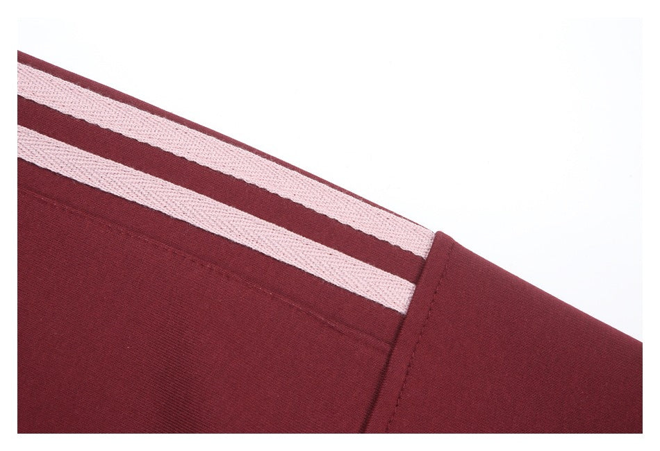 Close-up of two pale stripes running along the burgundy sleeve.