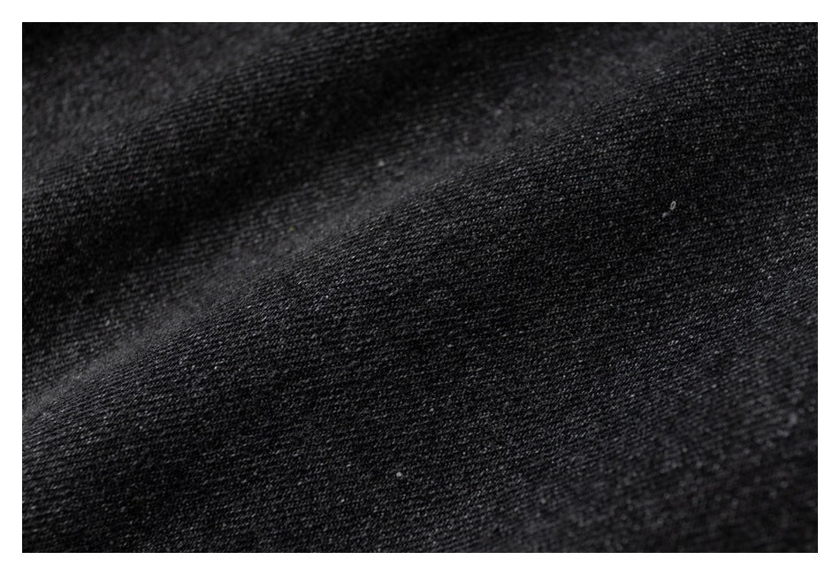 Macro view of dark charcoal knit fabric showing its fine textured weave.