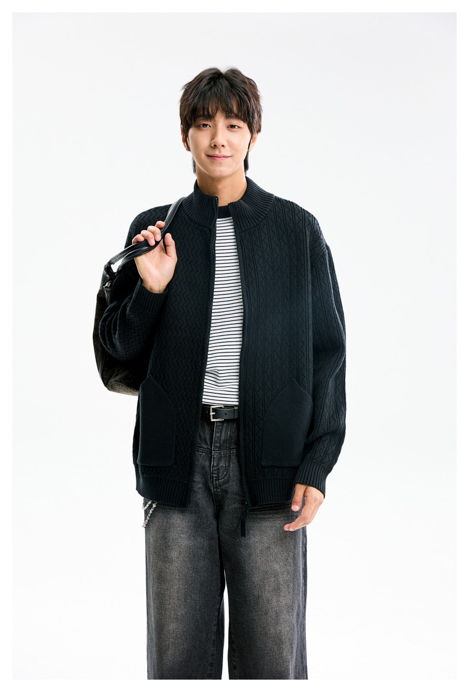 Front view of a model wearing a dark patterned zip cardigan with a stand collar and two patch pockets.