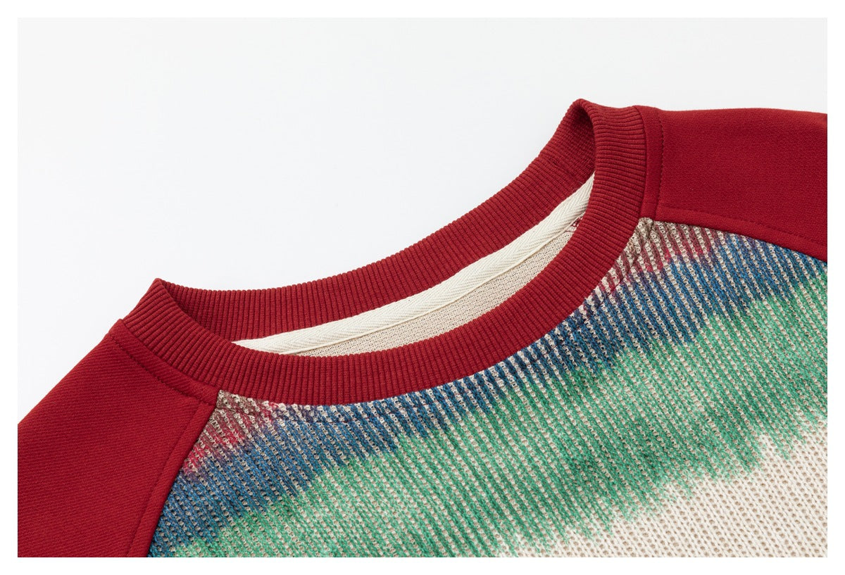 Close-up of a multicolored knit top with a red ribbed crew neckline and red shoulder panels.