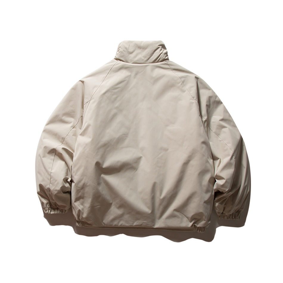 Back view of a light beige jacket with a high collar, raglan sleeves, and elasticated cuffs and hem.
