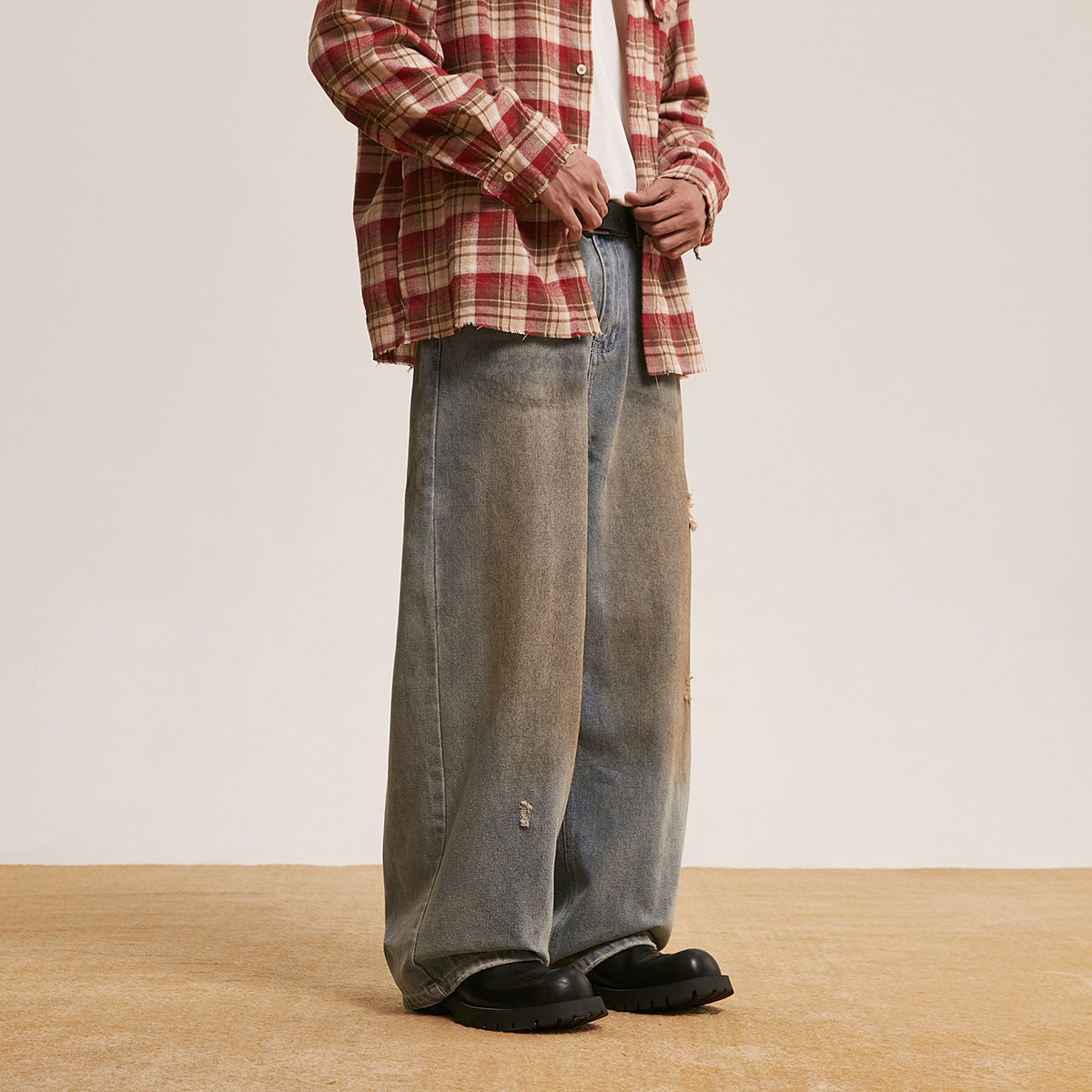 Model wearing loose gray washed jeans, shown at a front-side angle.