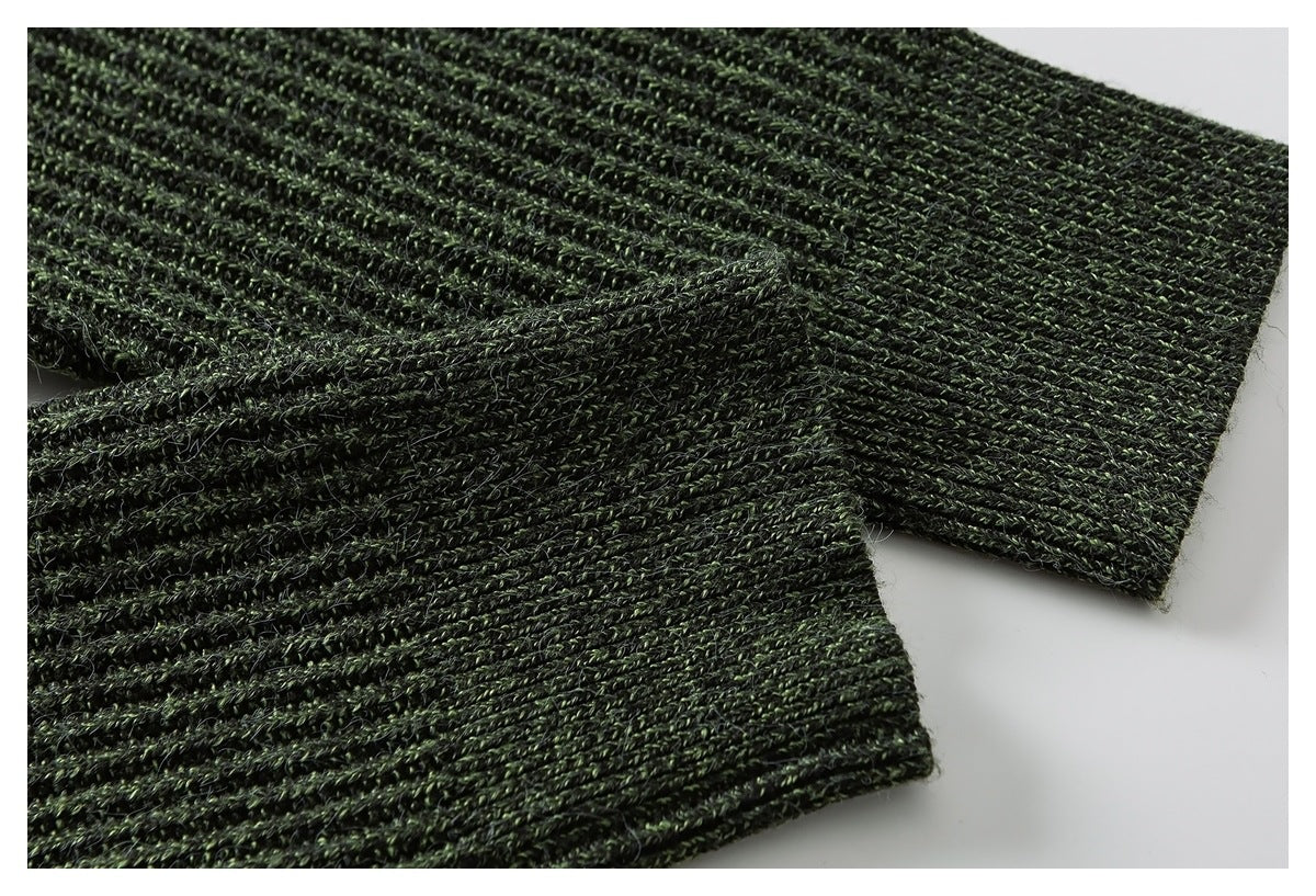 Close-up of deep green ribbed knit sections overlapping, showing the garment's textured stitching.