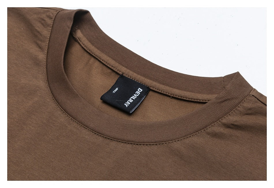 Close-up of a brown crew-neck shirt showing the ribbed collar, stitching, and sewn-in black neck label.