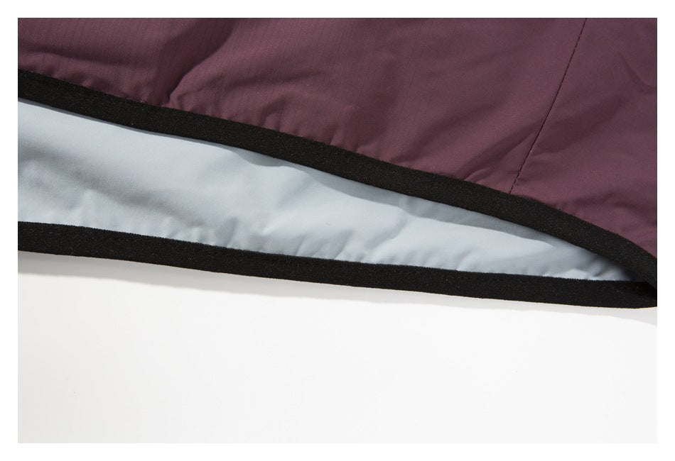 Close-up of the plum vest's hem, with black edging and a pale gray lining visible.