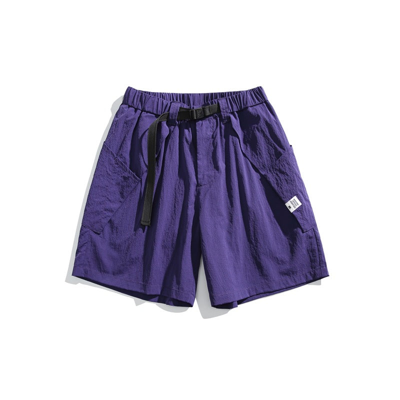 Purple knee-length shorts with elastic waist, black buckle belt and large side patch pockets, flat lay
