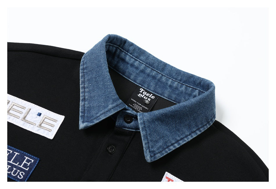 Close-up of a black polo shirt with a blue denim-style collar, black buttons, and a neck label.