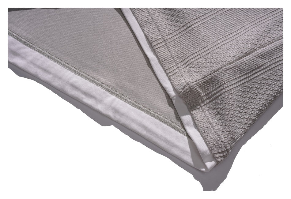 Close-up of the gray sweatshirt hem, showing the textured outer knit and smooth inner layer.