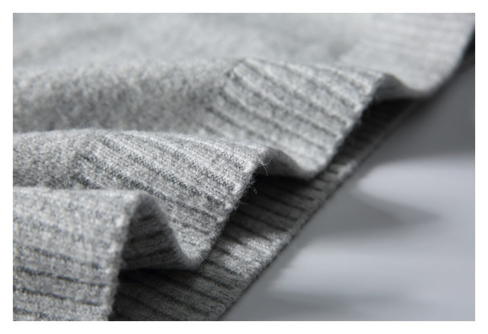 Close-up of light gray knit fabric with a folded, ribbed edge.