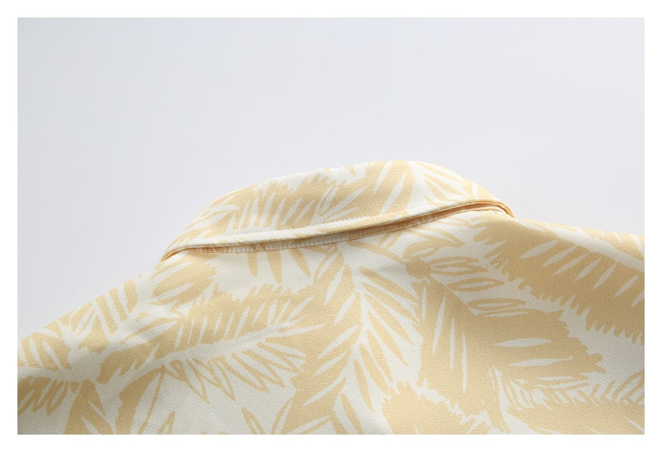Close-up of the collar on a cream shirt with a pale yellow leaf print.
