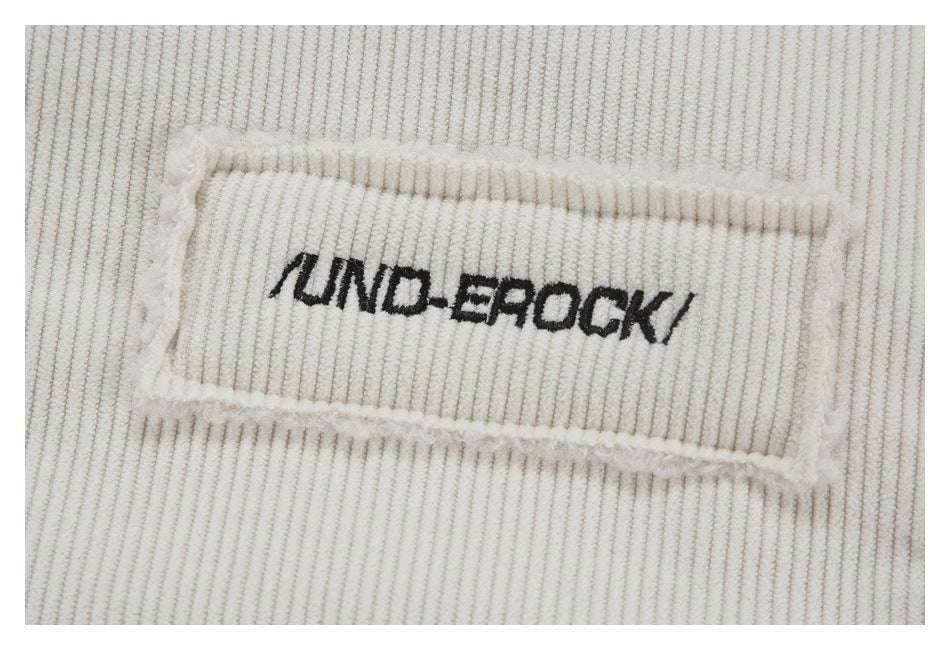 Close-up of a black wordmark patch sewn onto ivory ribbed fabric.