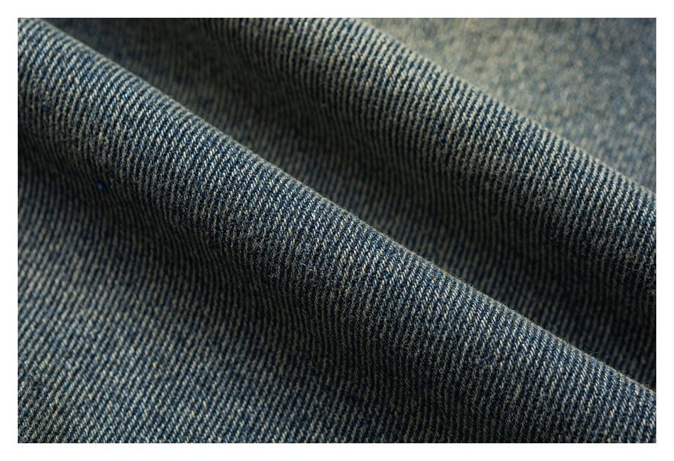 Macro view of dark blue denim twill texture draped in folds.