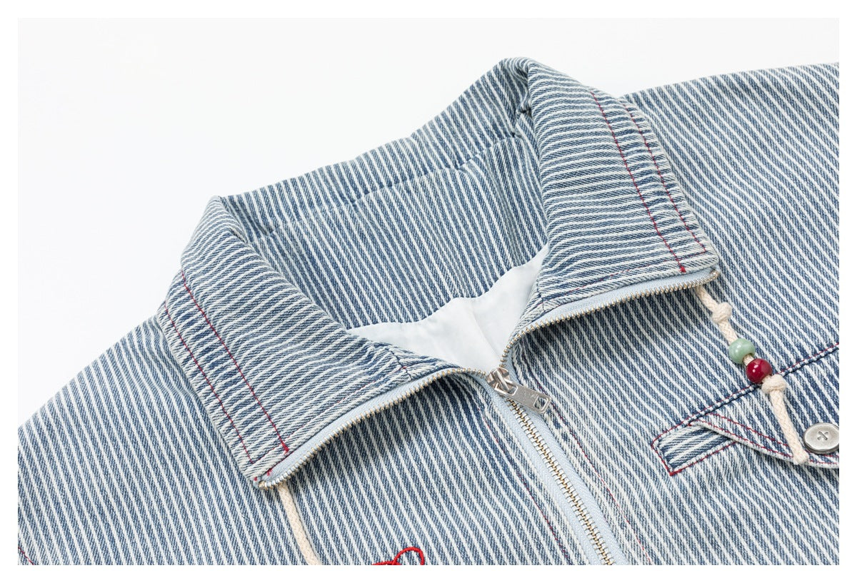Close-up of the jacket's pinstripe collar, silver zipper, buttoned chest pocket and knotted beaded drawcord.