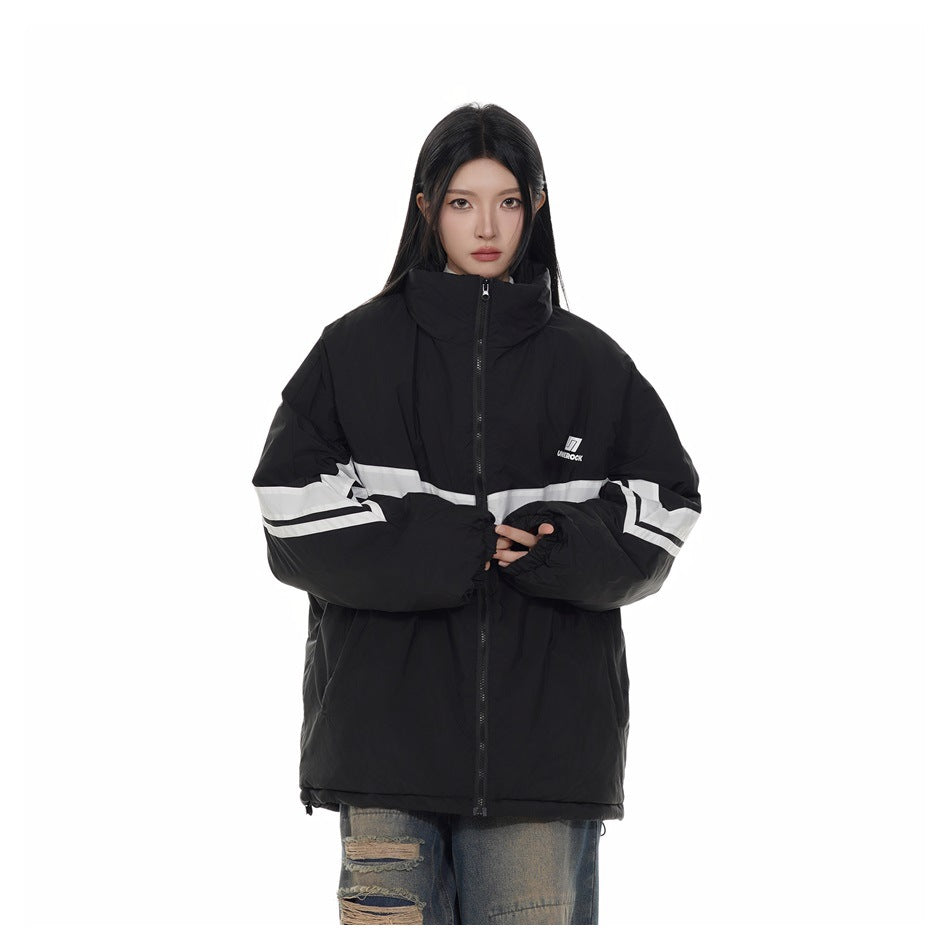 Model wearing an oversized black zip-up stand-collar jacket with white stripes, cropped at the hips