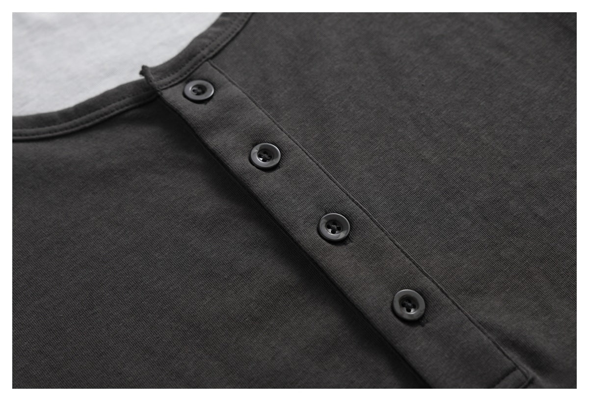 Close-up of a charcoal shirt's four-button placket and round neckline.